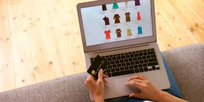 Frau kauft in einem Fakeshop Kleidung mit Kreditkarte
